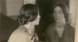A sepia toned photograph of Margaret Watkins looking into a mirror