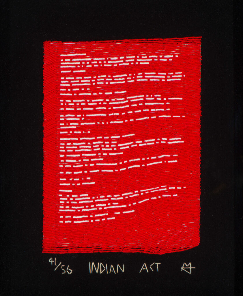Artwork by Nadia Myre, entitiled Indian Act. Glass beads, copy of one of the 54 pages of the Canadian Federal Government’s Indian Act, masking tape, thread, felt.