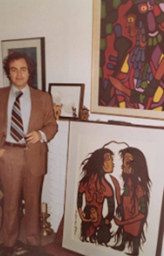 man standing beside morrisseau's painting