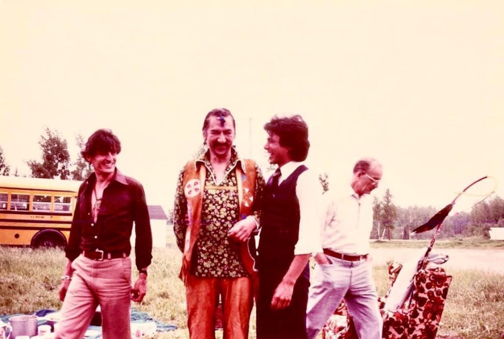 group of four men walking in a field